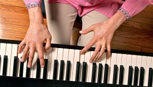 Overhead view of a woman's hands playing piano