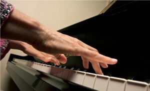 Up close image of hands playing piano