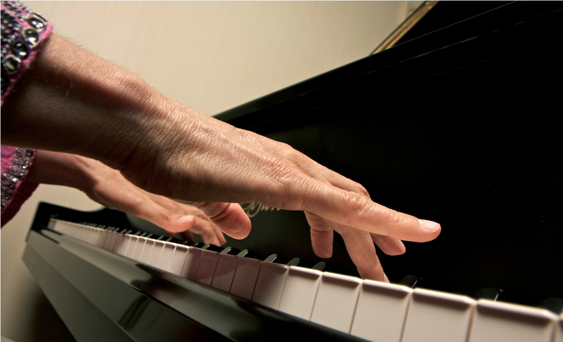 Up close image of hands playing piano