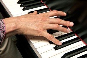 Hand playing piano up close