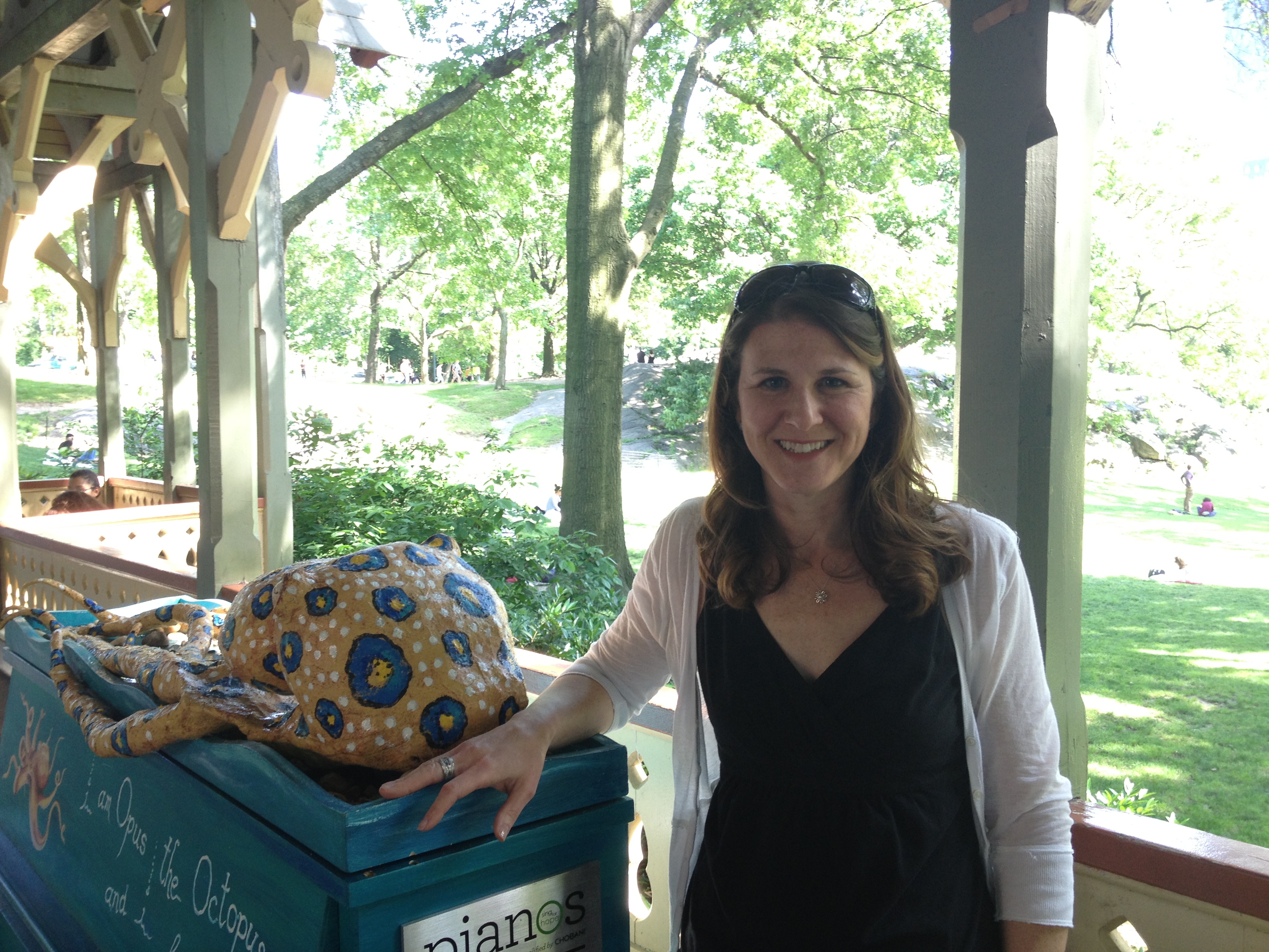 Stacy_Schwartz poses against blue piano with octopus sculpture in central park