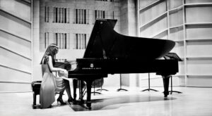 Black and white photo of Christina Kim performing on a Steinway grand piano